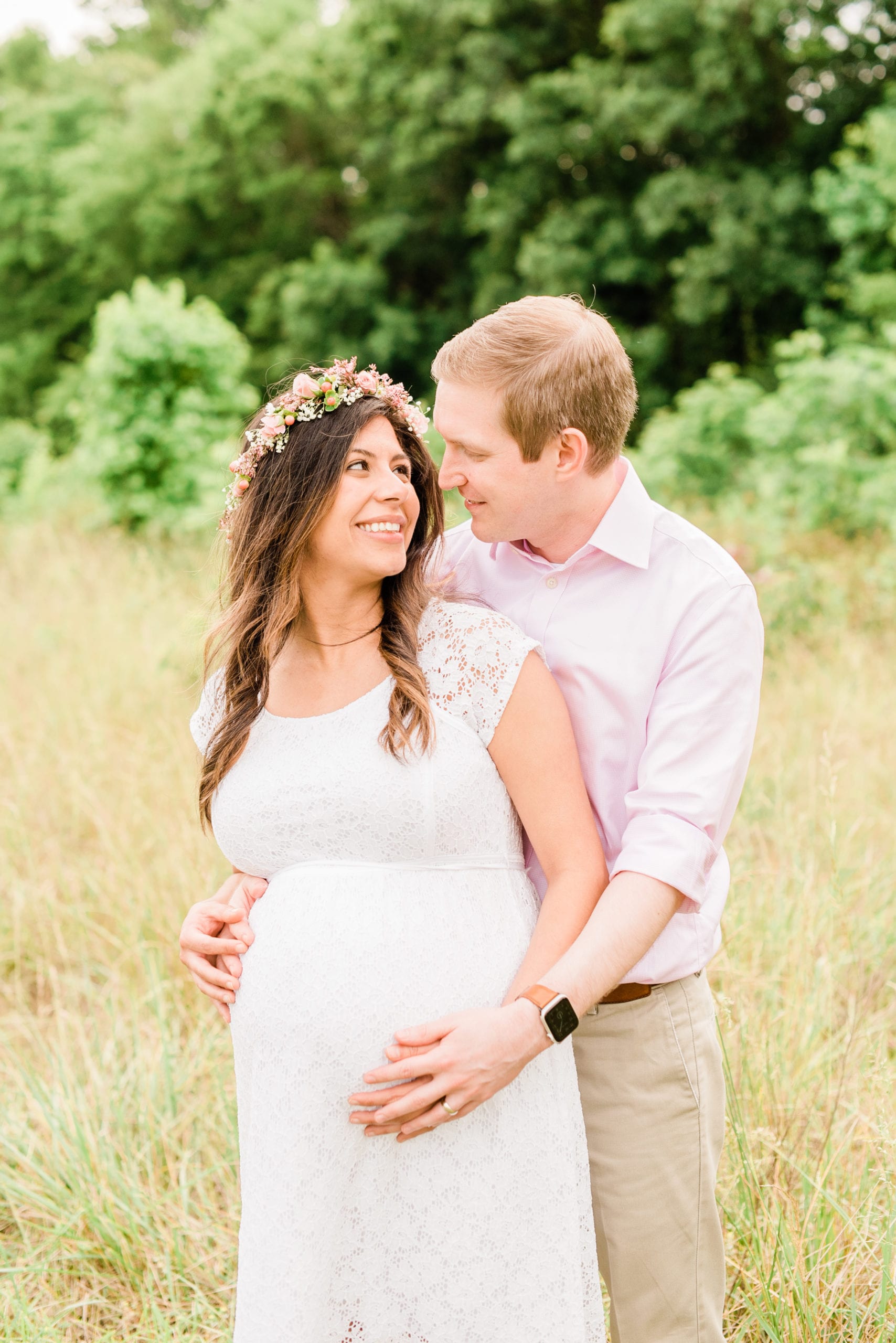 wake forest husband with his arms wrapped around his pregnant wife photo