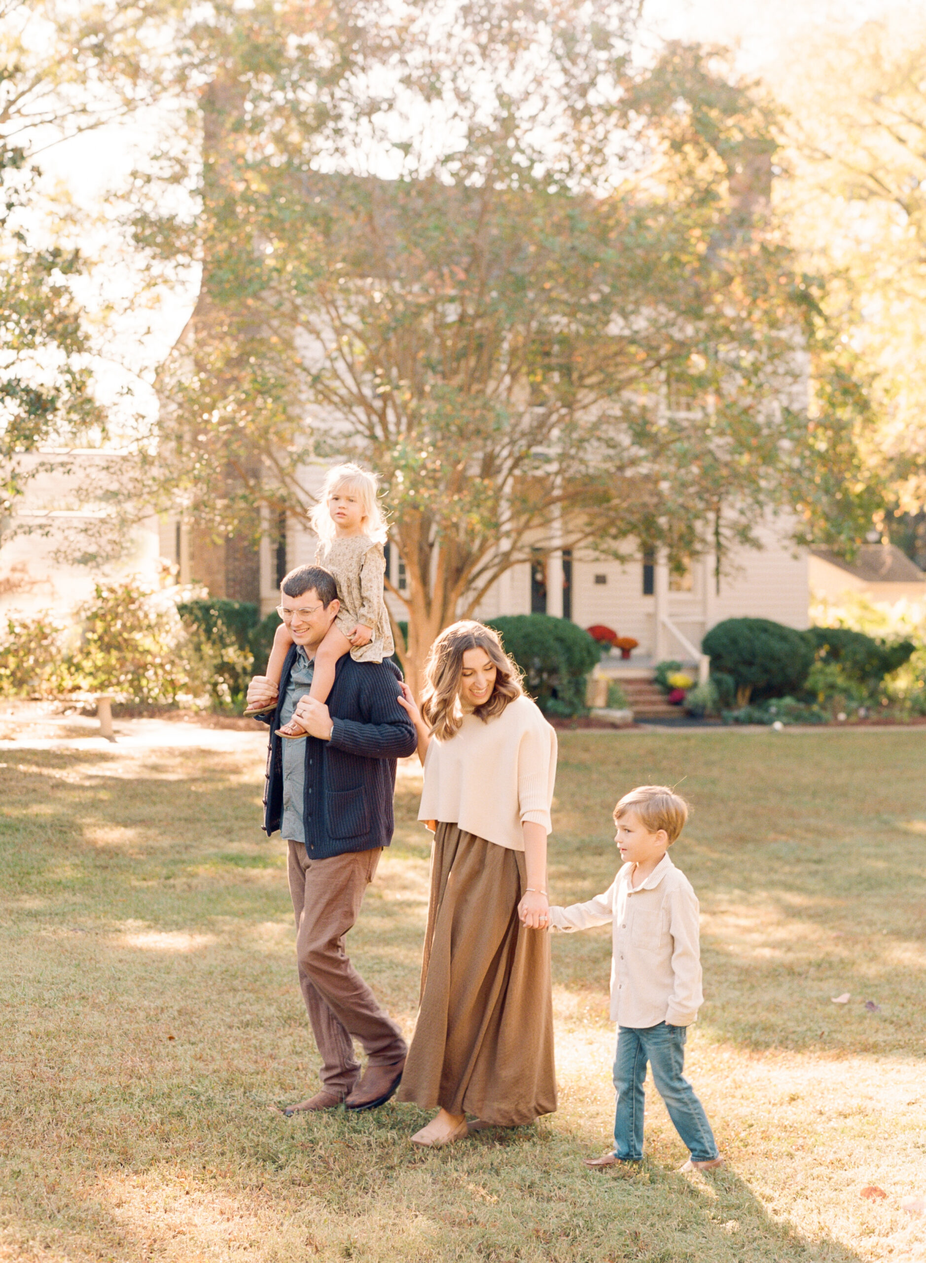 Family walking while holding hands. Tips for Family Photography by Raleigh family photographer A.J. Dunlap.