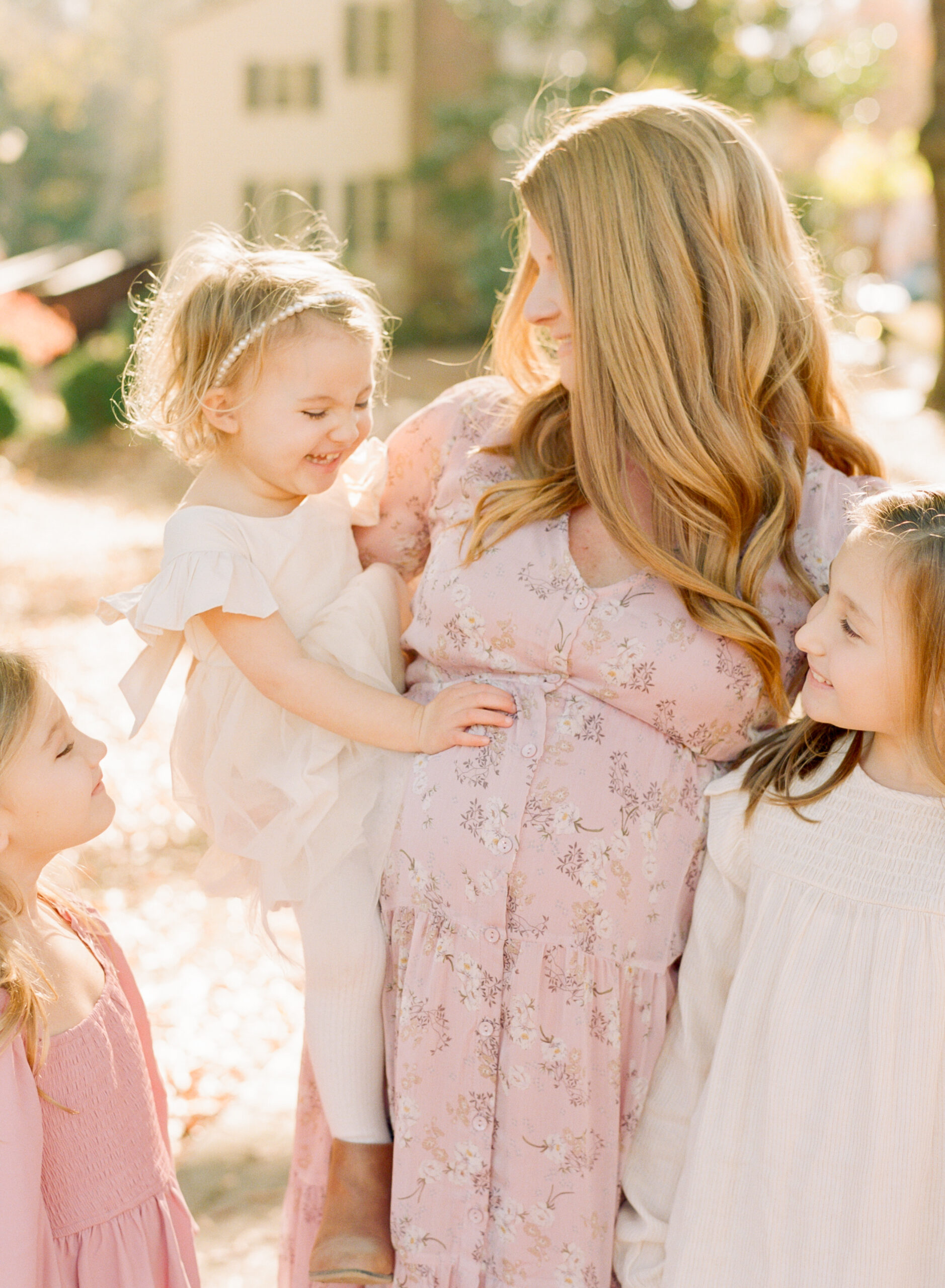 Toddler sits on mom’s pregnant belly and laughs. Check out these Reasons to take maternity photos by Raleigh maternity photographer A.J. Dunlap.