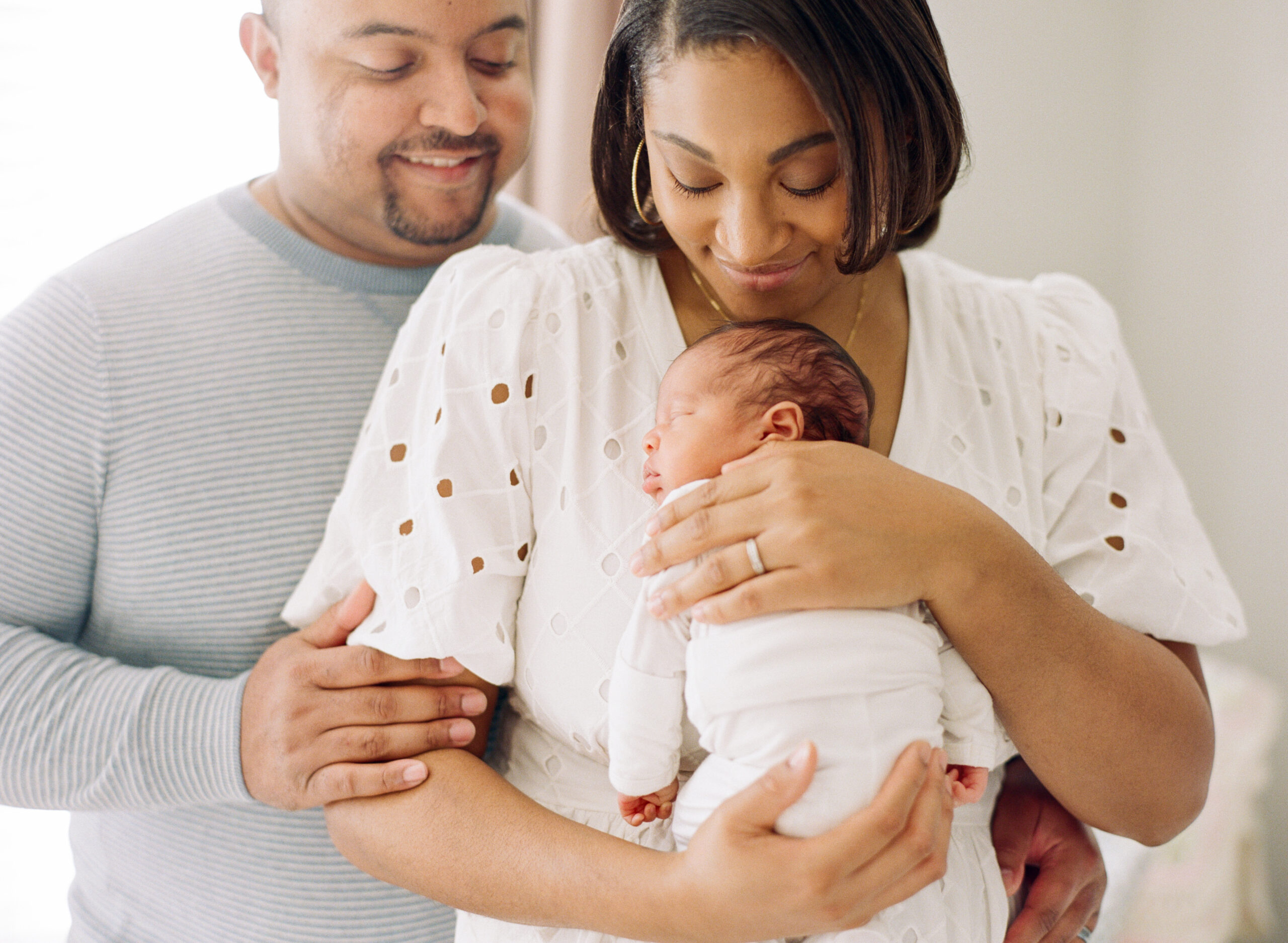 Family cradles newborn girl. Newborn Photographers in Raleigh image by A.J. Dunlap Photography.